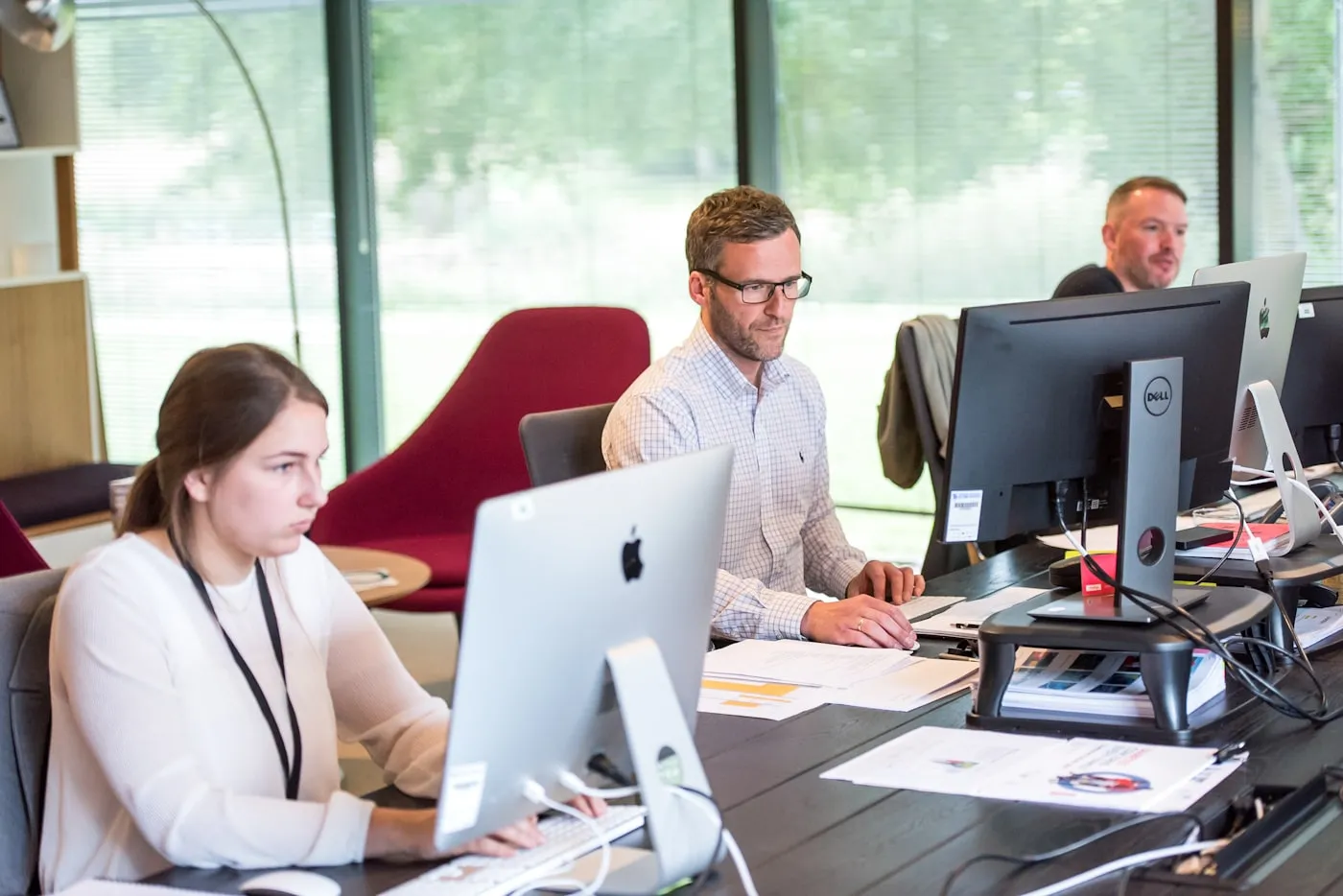 Team collaborating in a modern office using Microsoft 365 tools