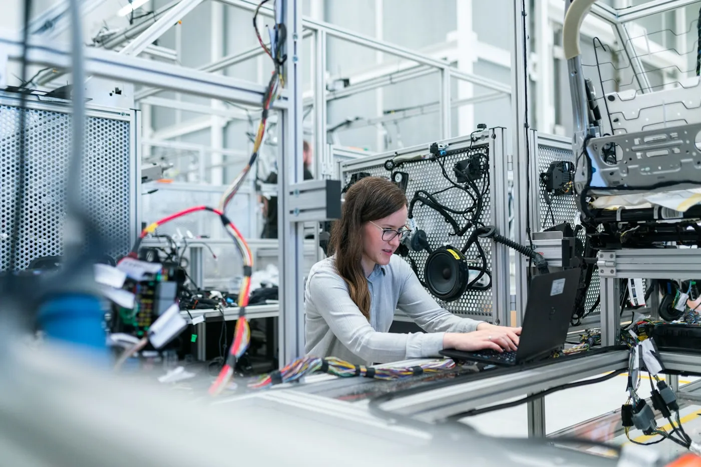 Plant floor engineer reviewing control systems on a laptop